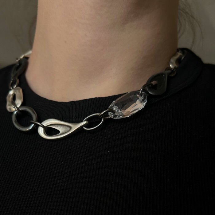 Modernus vėrinys su Swarovski kristalu ir hematitu - subtilus, bet išraiškingas stiliaus akcentas. Skirtingų formų metalinės jungtys kuria šiuolaikišką, dinamišką dizainą, o skaidrus Swarovski kristalas suteikia lengvo spindesio ir elegancijos. Puikiai tinka tiek kasdieniam įvaizdžiui, tiek ypatingoms progoms.