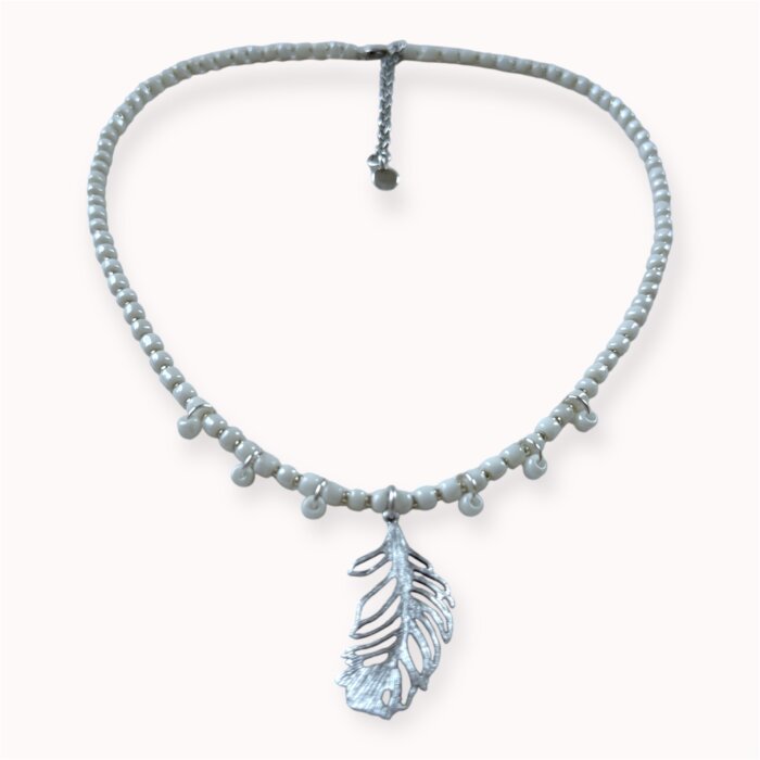 Baltas vėrinys su sidabruotos plunksnos pakabuku